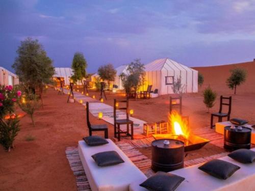 a group of tables and fires in the desert at merzouga camping in Merzouga