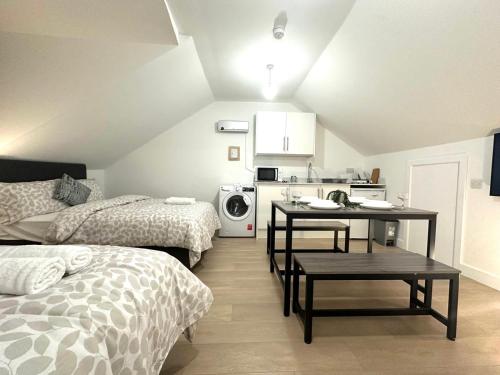 a small room with two beds and a kitchen at Finsbury Park Studio Apartments in London