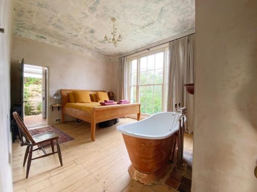 a large bathroom with a tub and a bed at Sea Garden in Hastings