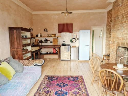 a kitchen and living room with a bed and a table at Sea Garden in Hastings