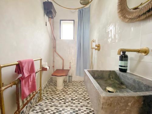 a bathroom with a large stone tub and a toilet at Sea Garden in Hastings