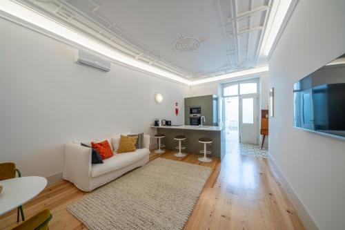 a white living room with a couch and a kitchen at Good Old Days - Guesthouse in Caldas da Rainha