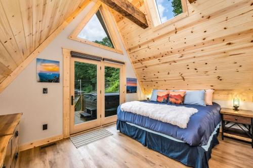 a bedroom in a cabin with a bed and a window at High Peak At West Jefferson A Frame in West Jefferson