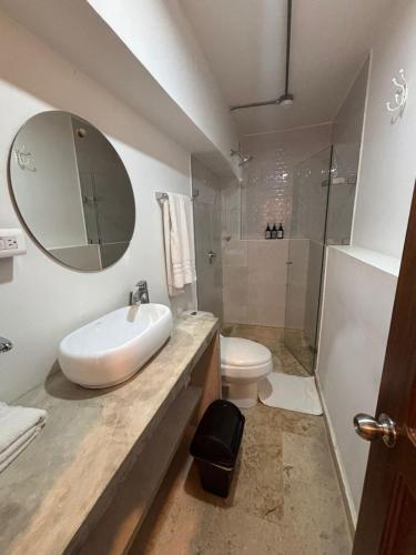 a bathroom with a sink and a toilet and a mirror at Del Mar Guest House in Cartagena de Indias