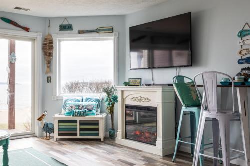 een woonkamer met open haard en tv bij Coastal Serenity 108 Beachfront Condo Near Downtown in Fivemile Corner