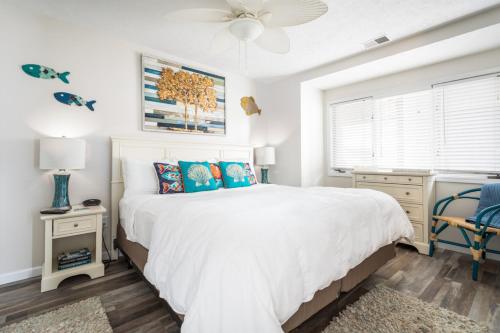 een slaapkamer met een groot wit bed en een raam bij Coastal Serenity 108 Beachfront Condo Near Downtown in Fivemile Corner