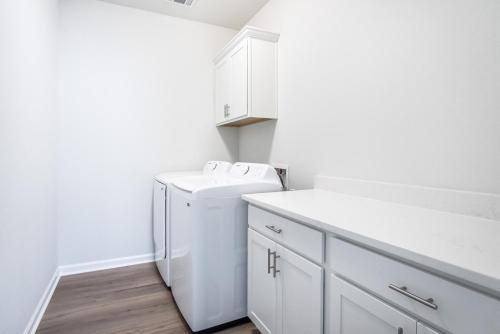a white bathroom with a sink and a washer at The Tigers Pathway House near LSU Stadium - BC1034 in Collegetown