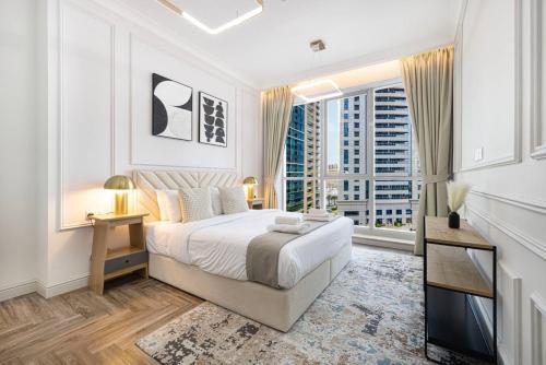 a white bedroom with a bed and a large window at StayMada - Torch Tower Elegant Marina Retreat in Dubai