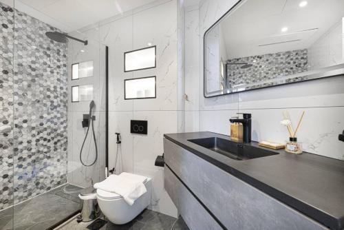 a bathroom with a sink and a toilet and a shower at StayMada - Torch Tower Elegant Marina Retreat in Dubai