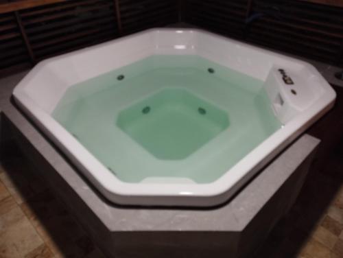 a white bath tub with a sink in a room at Casa Pitanga in Cabo Frio