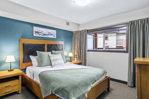 ein Schlafzimmer mit einem Bett mit blauen Wänden und einem Fenster in der Unterkunft Rockies Getaway 2BR with Patio Hot Tub and Gym in Dead Man's Flats