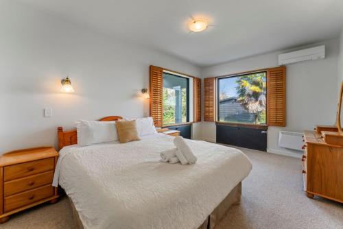 une chambre avec un lit avec un animal en peluche dessus dans l'établissement Ultimate Lakefront Getaway, à Waitahanui