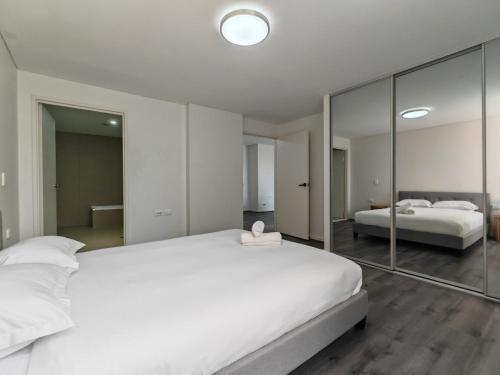 a bedroom with two beds and a large mirror at Modern 2BR apartment in Asquith in Asquith