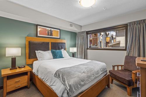 a bedroom with a bed and a chair and a window at Cozy Oasis 2BR with Hot Tub and Gym 10 Mins to DT in Dead Man's Flats