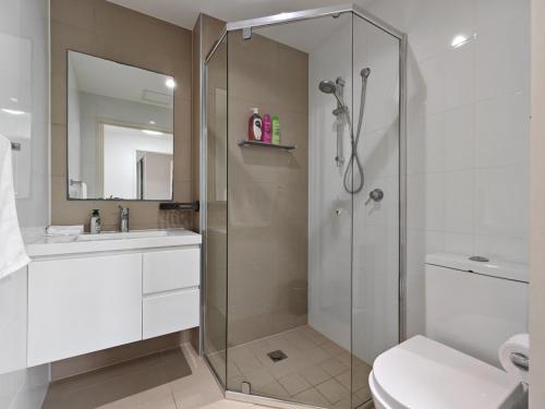a bathroom with a shower and a toilet and a sink at Modern 2BR apartment in Asquith in Asquith