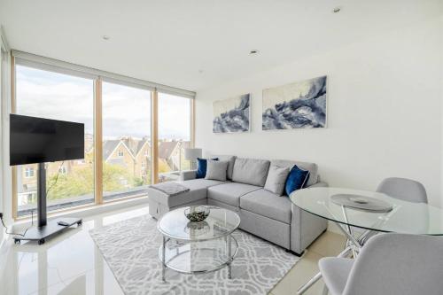 a living room with a couch and a tv at Elegant One Bed Penthouse with Terrace in London