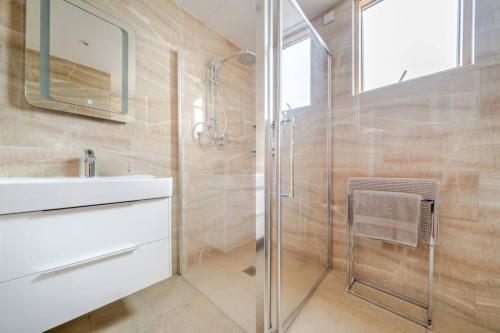 a bathroom with a glass shower and a sink at Elegant One Bed Penthouse with Terrace in London