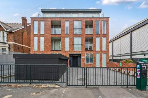 a brick building with a black fence in front of it at Elegant One Bed Penthouse with Terrace in London