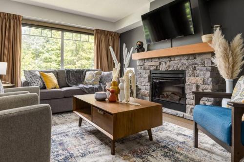 a living room with a couch and a fireplace at Lovely 3BR condo with Hot Tub at the Edge of Canmore in Dead Man's Flats