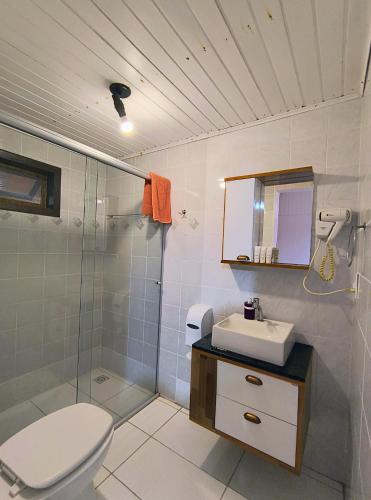a bathroom with a toilet and a sink and a shower at Pousada Enseada das Conchas in Ilha do Mel