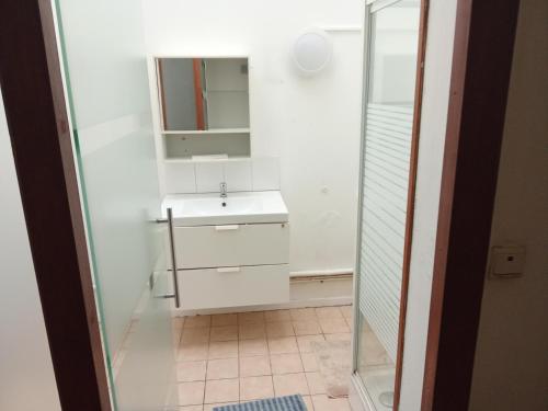 a white bathroom with a sink and a mirror at Night in Liège
