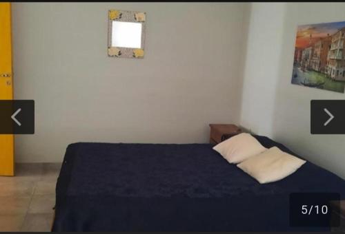 ein Schlafzimmer mit einem Bett mit einer blauen Decke und einem Fenster in der Unterkunft San Antonio de Arredondo in San Antonio de Arredondo