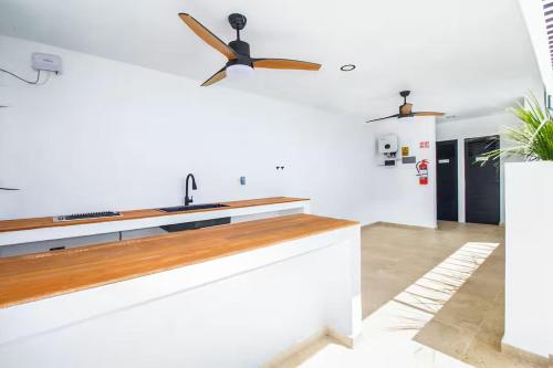 a kitchen with white walls and a ceiling fan at Cozy Playa Escape Pool, Beach & 5th Avenue in Playa del Carmen