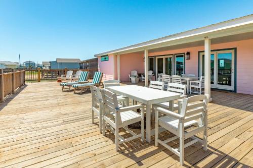 a deck with a white table and chairs on it at Absolutely Stunningly Decorated Posh Pink Pearl in Surfside Beach