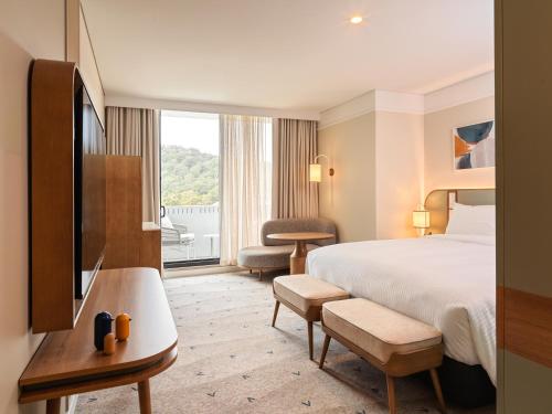 a hotel room with a bed and a large window at voco Gosford by IHG in Gosford