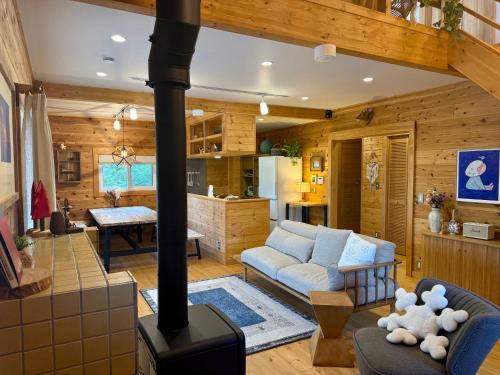 a living room with a woodburning stove in a house at Best Day Ever Furano Lodges in Furano