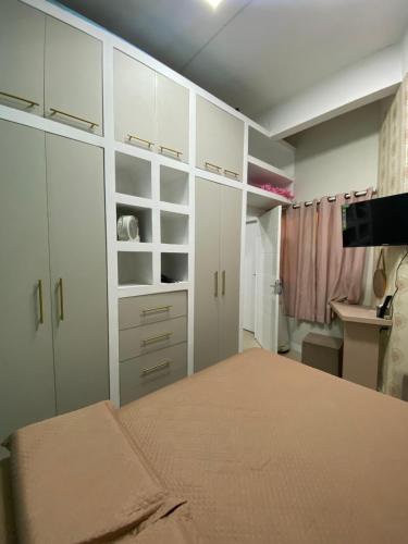 a bedroom with white cabinets and a bed at Apartamento Gaya - Perto da Praia e Confortável in Balneário Camboriú