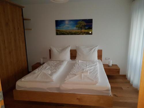 a bed with white sheets and pillows in a bedroom at Galsterberg in Gröbming