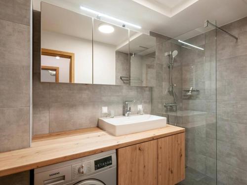 a bathroom with a sink and a washing machine at Galsterberg in Gröbming