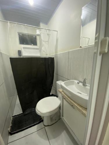a bathroom with a white toilet and a sink at Apartamento Gaya - Perto da Praia e Confortável in Balneário Camboriú