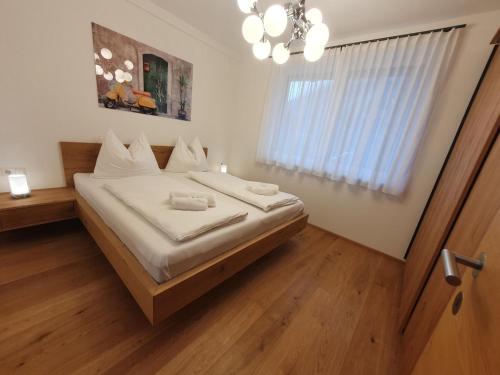 a bedroom with a bed with white sheets and a window at Grimming in Gröbming