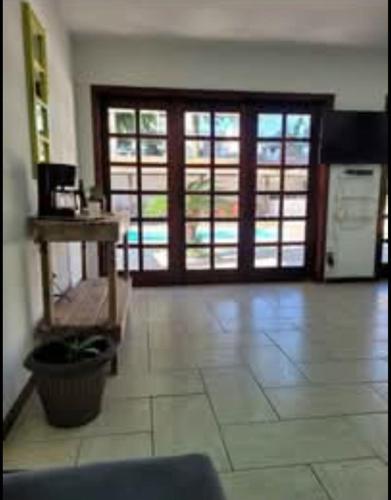 a living room with a large door and a room with a table at Hostel da Dani in Balneário Camboriú