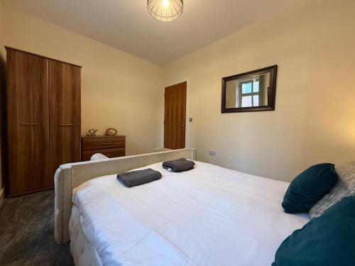 a bedroom with a large white bed and a mirror at Modern 2BR Flat in Bradford City Centre! in Bradford