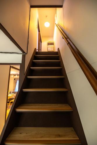 a staircase in a building with wooden steps at oyadoya gifu kano 岐阜駅徒歩12分 名古屋駅35分 大人数貸切 最大8名 駐車場有り in Gifu