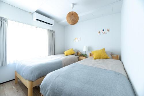 two beds sitting next to each other in a bedroom at oyadoya gifu kano 岐阜駅徒歩12分 名古屋駅35分 大人数貸切 最大8名 駐車場有り in Gifu