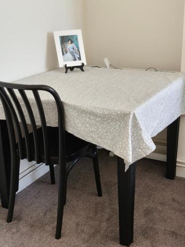 una mesa con una silla y una foto en ella en Fulham Palace Residence, en Londres