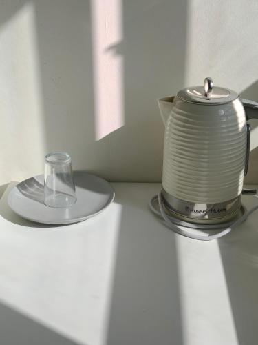 un hervidor de agua y un vaso sobre una mesa en Fulham Palace Residence, en Londres
