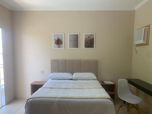 a bedroom with a bed and a desk with a chair at Suíte de Casal Privativa com Sacada in Sao Jose do Rio Preto