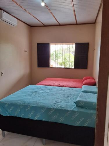a bedroom with a large bed in a room at Casa c wifi, 2 Qts, 3 camas, ganchos p redes e estacionamento in Santarém