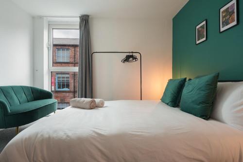 a bedroom with a large bed with a green wall at 2 BR Apt By Eason Stays Short Lets & Serviced Accommodation Kelham Island Sheffield With Free Wifi in Midland