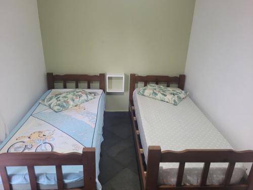 two twin beds in a small room at Apartamento Relax Enseada Bertioga SP in Bertioga