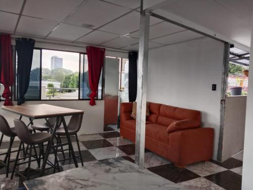 ein Wohnzimmer mit Sofa und Tisch in der Unterkunft Habitaciones Clásica en lo mejor de SS city in San Salvador