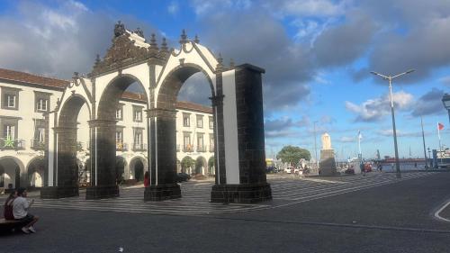 a building with an arch in the middle of a street at Portas Residence, Quartos & Suites - Ponta Delgada City Center in Ponta Delgada