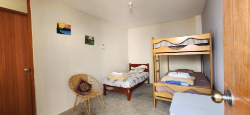 a bedroom with two bunk beds and a chair at Pacasmayo Surf Las Torres in Pacasmayo