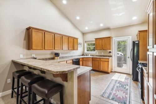 a kitchen with wooden cabinets and a large island with bar stools at Bitterroot Escape in Whitefish