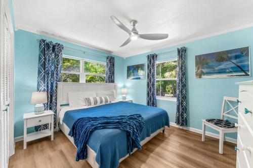 a blue bedroom with a bed and two windows at 1375 Bay Shore Drive in Cocoa Beach